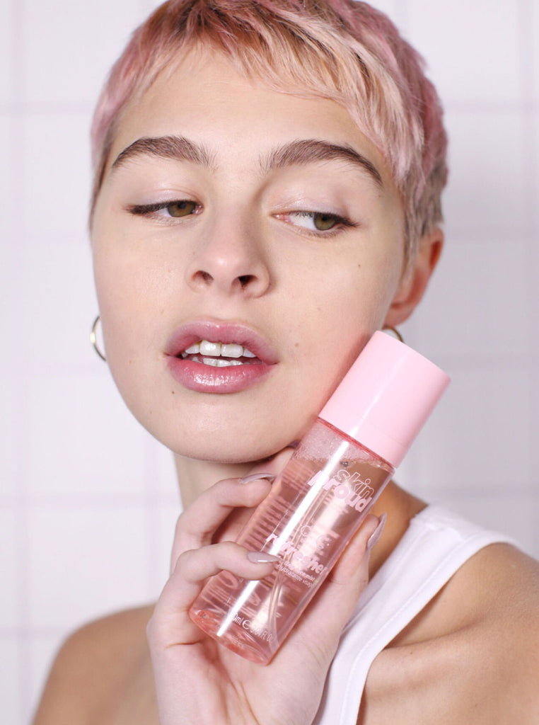 Model holding bottle of Skin Proud Refresher